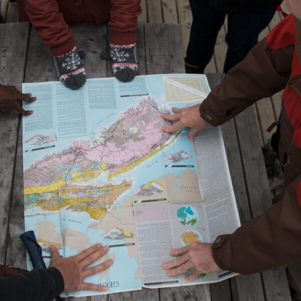 People holding a map on top of a table.